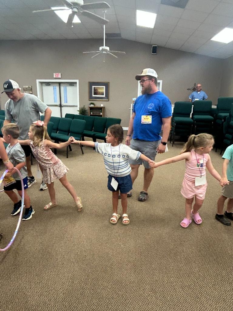 Children holding hands in a chain activity during VBS 2026