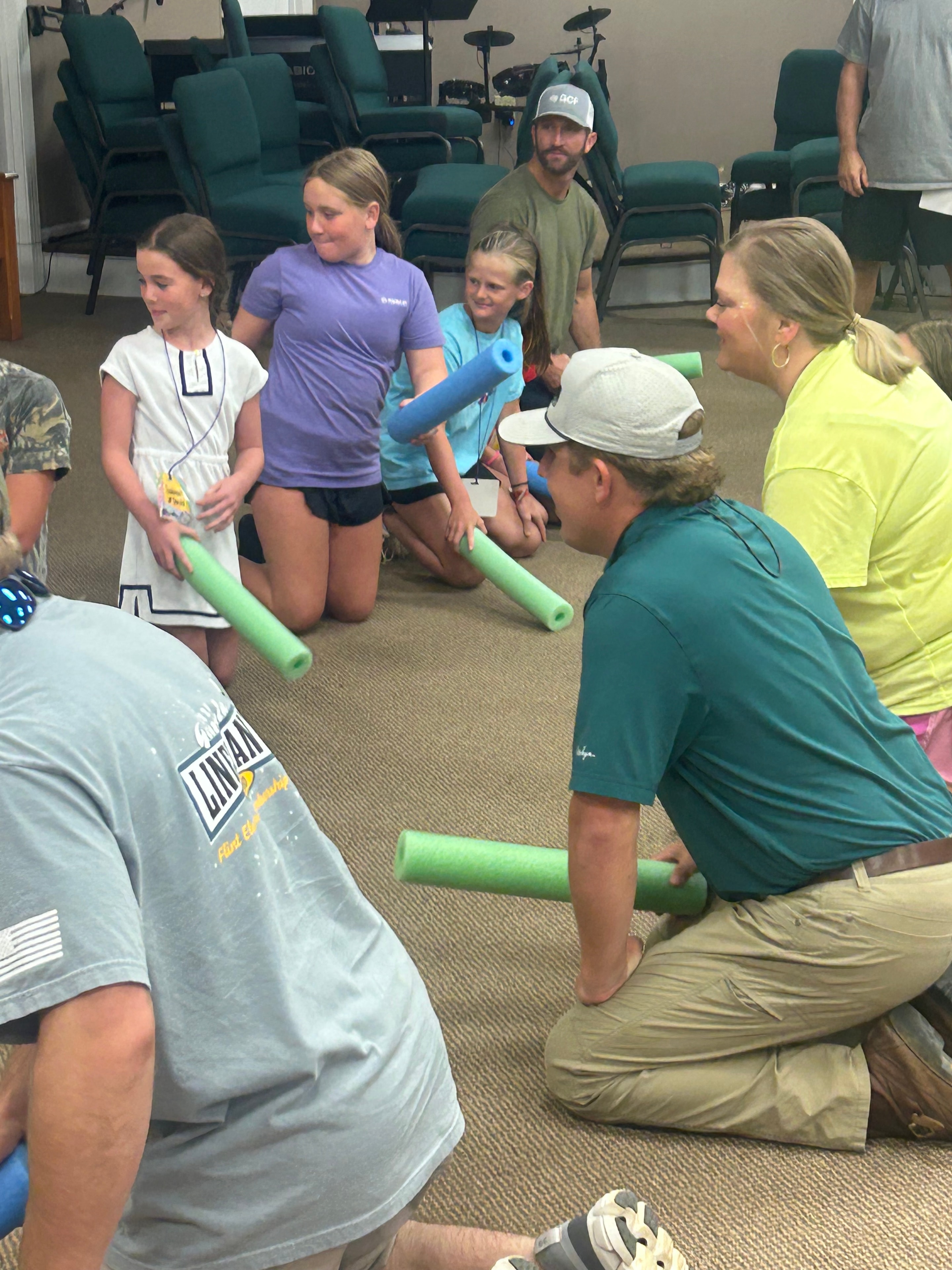 Children and volunteers with pool noodles in the sanctuary at VBS 2026