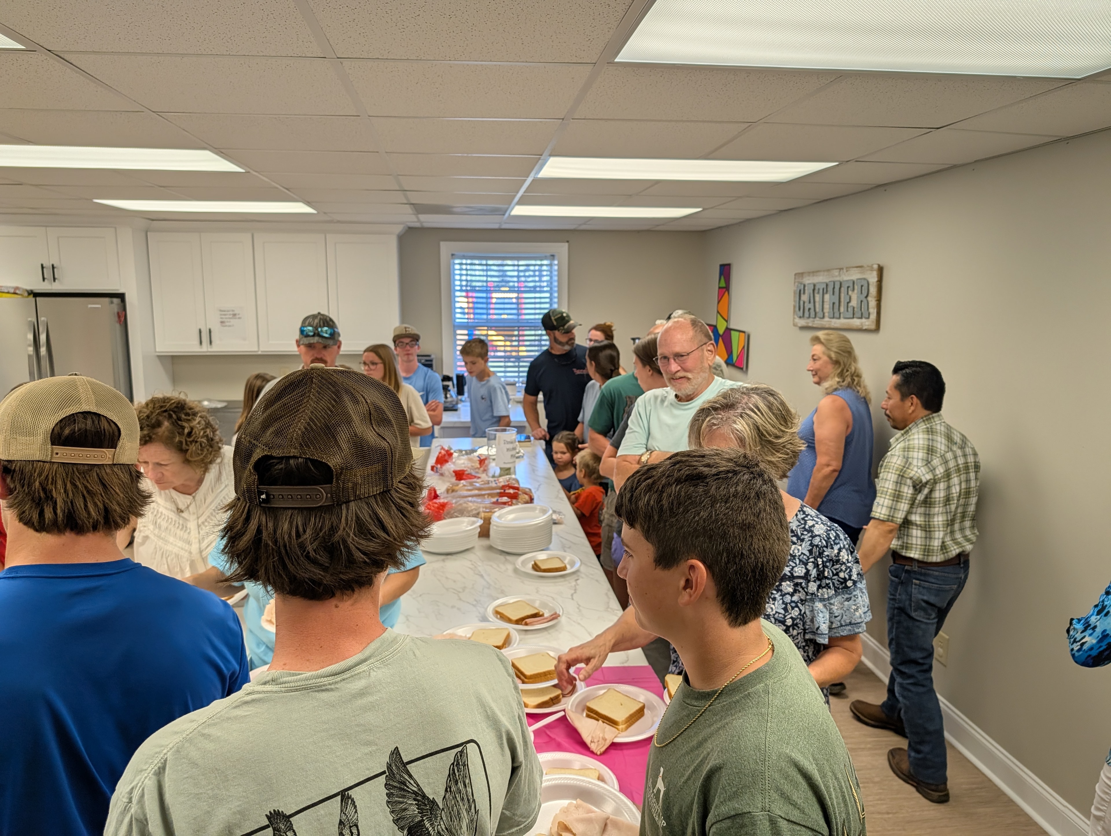 Congregation gathering around the serving table at the Wednesday evening fellowship meal